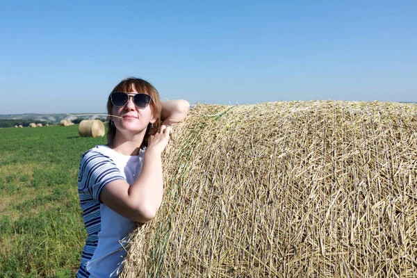 Tourist posing with bales of straw — Stock Photo, Image