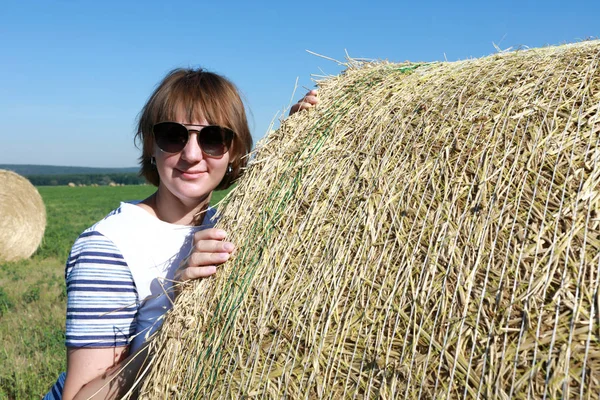 Person posing next to bales of straw — Stock Photo, Image