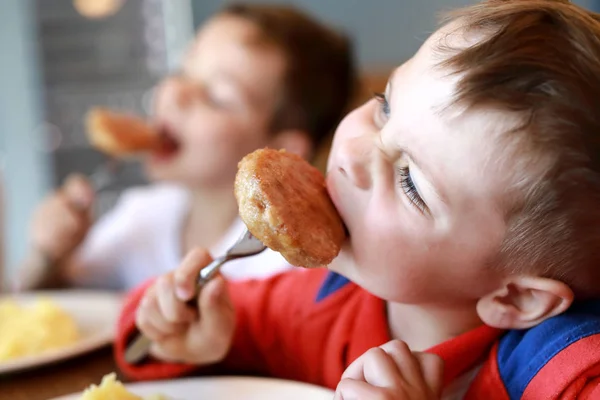 Dois irmãos comendo costeletas — Fotografia de Stock