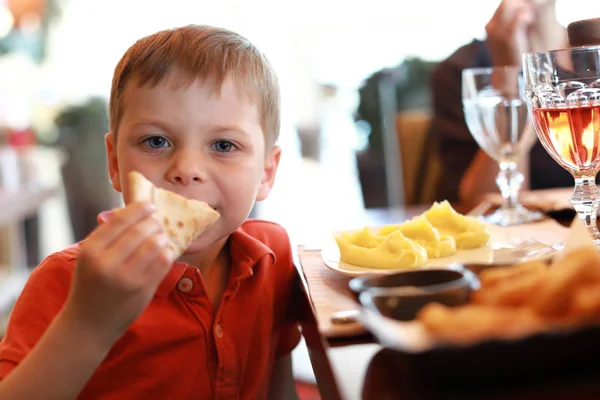 Niño comiendo pizza en restaurante — Foto de Stock