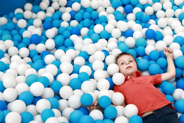 Niño acostado en la piscina de pelota — Foto de Stock