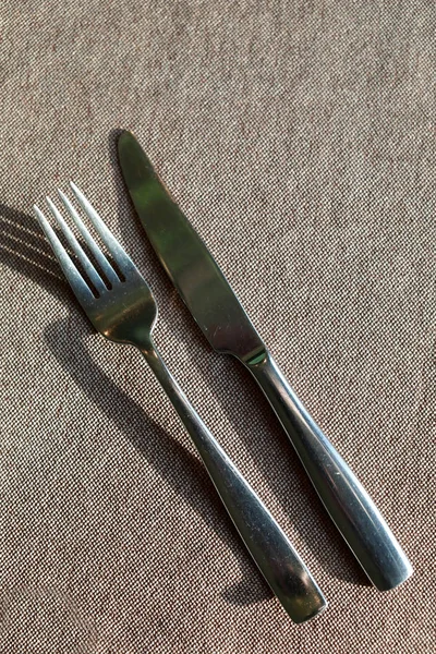 Knife and fork on tablecloth — Stock Photo, Image