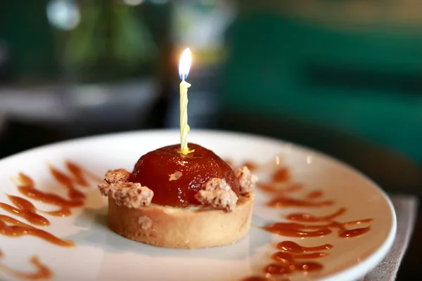 Gâteau avec bougie allumée — Photo