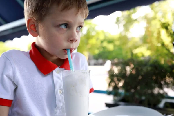 Barn dricker milkshake genom halm — Stockfoto