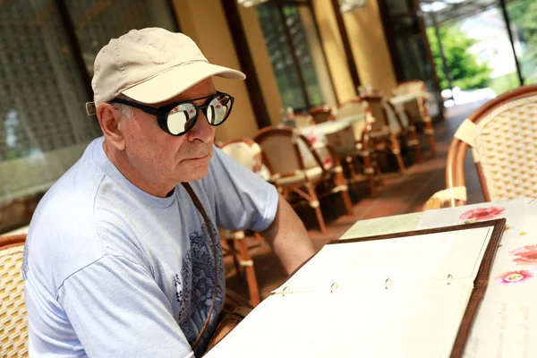 Uomo anziano con libro menu — Foto Stock