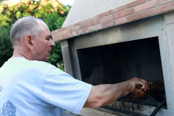 Homem sênior cozinhar kebabs — Fotografia de Stock