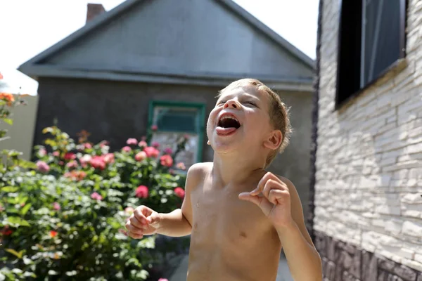 Çocuk ağız ile su damlaları yakalar — Stok fotoğraf