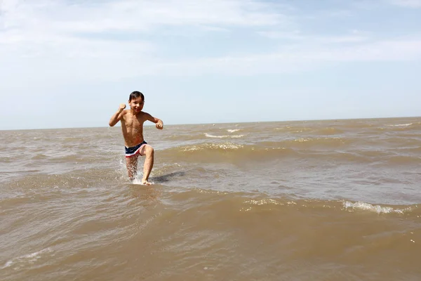 Rapaz a correr no mar — Fotografia de Stock