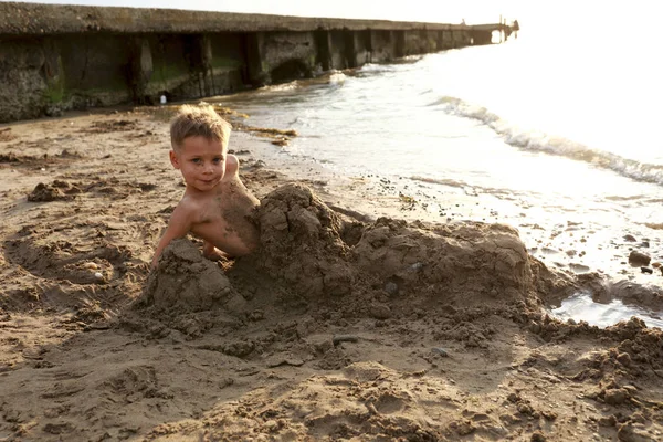 ビーチで砂に埋もれた子供 — ストック写真