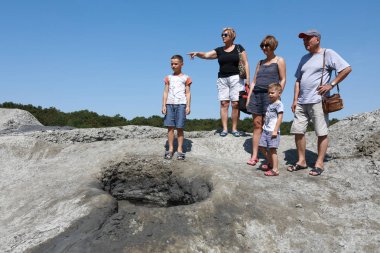 Çamur havuzuna bakan insanlar