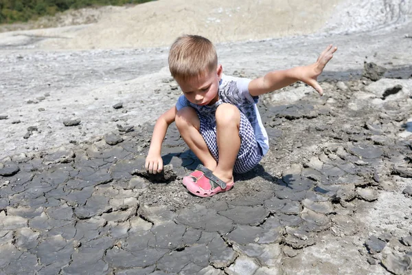 Chlapec se po cestě odhrne z hlíny — Stock fotografie