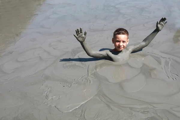 泥のプールで休んでいる子供 — ストック写真