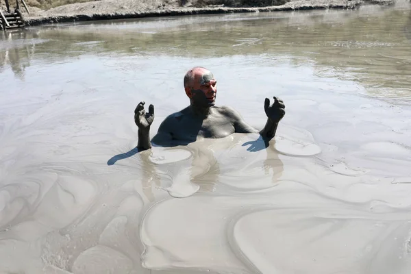 Homem idoso descansando na lagoa de lama — Fotografia de Stock