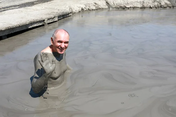 Äldre man vilar i lera pool — Stockfoto