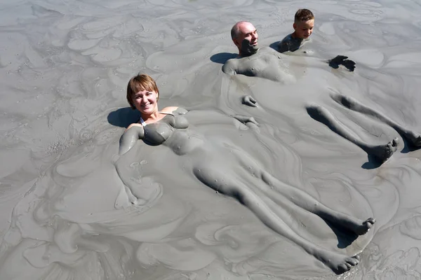 Familjen vilar i lera pool — Stockfoto