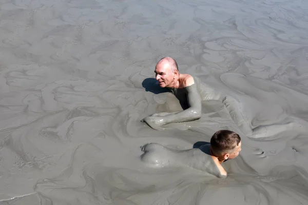 Grand-père et petit-fils reposant dans un étang de boue — Photo