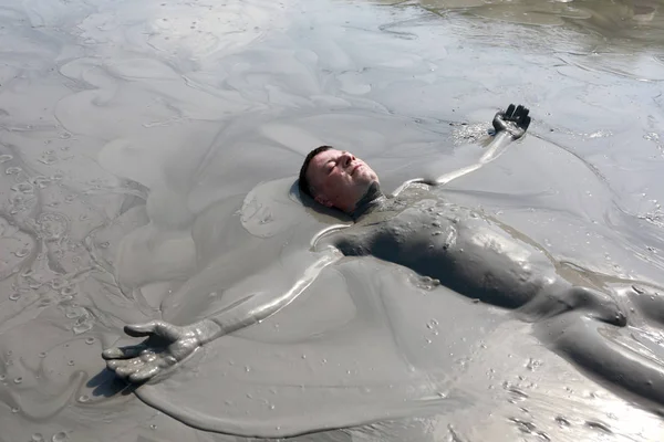 Man som ligger i lera pool — Stockfoto