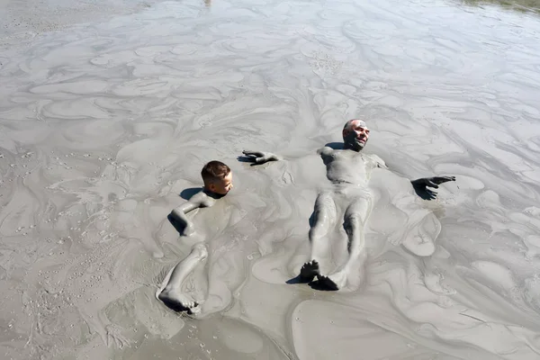 Nonno e nipote sdraiati nella piscina di fango — Foto Stock