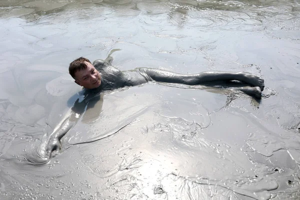 Homme reposant dans un étang de boue — Photo