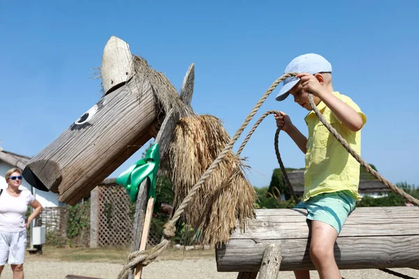 Bambino seduto su un cavallo di legno — Foto Stock