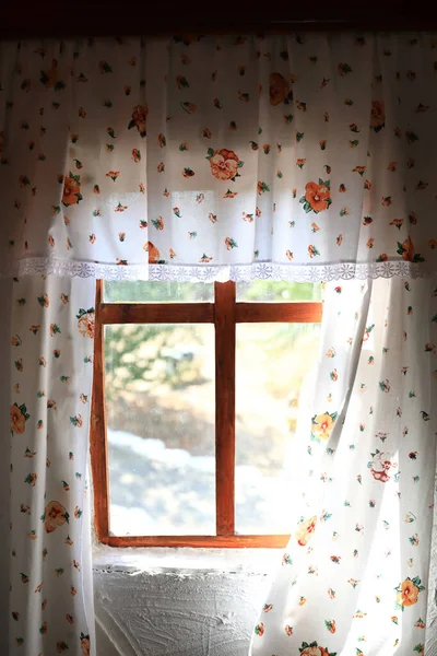 Floral curtains in rustic hut — Stock Photo, Image