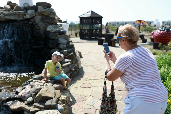 Vnuk babička fotografie s smartphone — Stock fotografie