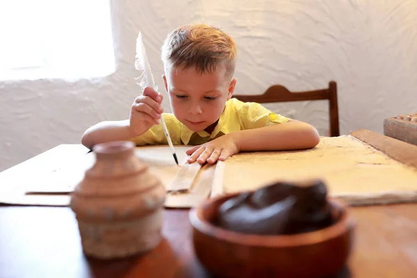 Kid writing with quill pen — Stock Photo, Image