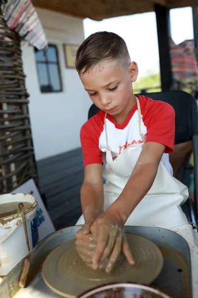 Мальчик работает на гончарном круге — стоковое фото