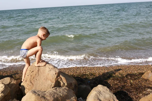 Boy climbing on stone — Stock Photo, Image