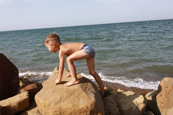 Niño escalando en piedra — Foto de Stock