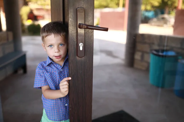 Boy opening mirrored front door — Stock Photo, Image