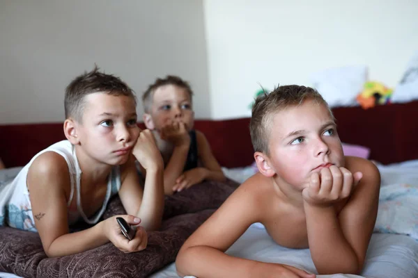 Tre gutter som ser på TV – stockfoto