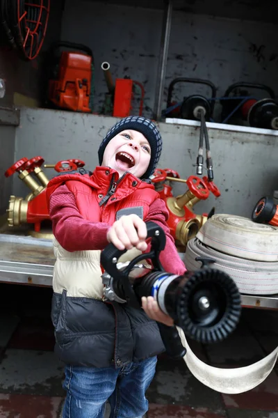 Niño con manguera de fuego —  Fotos de Stock