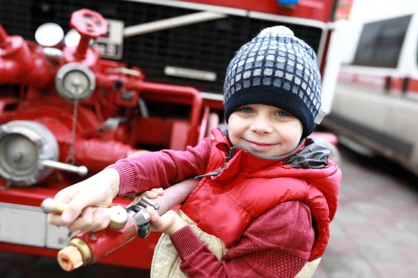 Niño con tubo de manguera de fuego — Foto de Stock