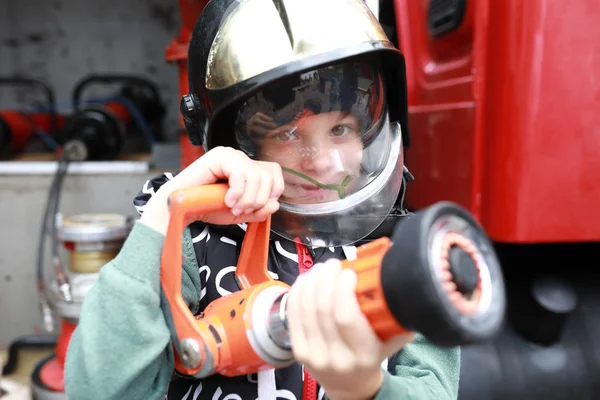 Kid with fire hose — Stockfoto