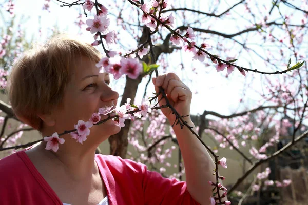 Žena Čichání Broskvoně Květy Jaře — Stock fotografie