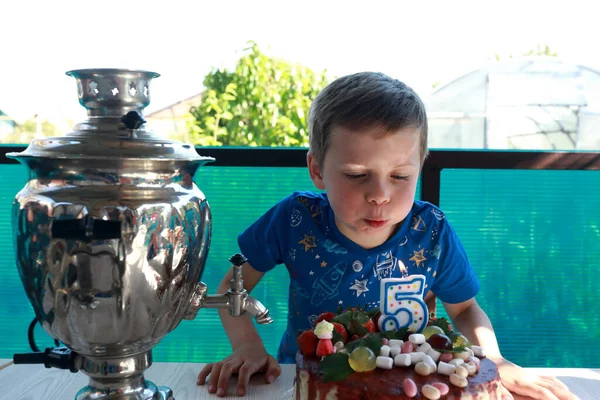 生日男孩在后院吹灭了蛋糕上的蜡烛 — 图库照片