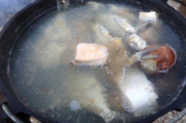 Rus çorbası kazanda yanan çeşitli balıklardan pişirilir.