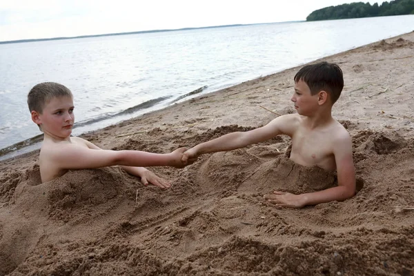 2人の子供がロシアのオスタシュコフのセリガー湖の砂浜で遊ぶ — ストック写真
