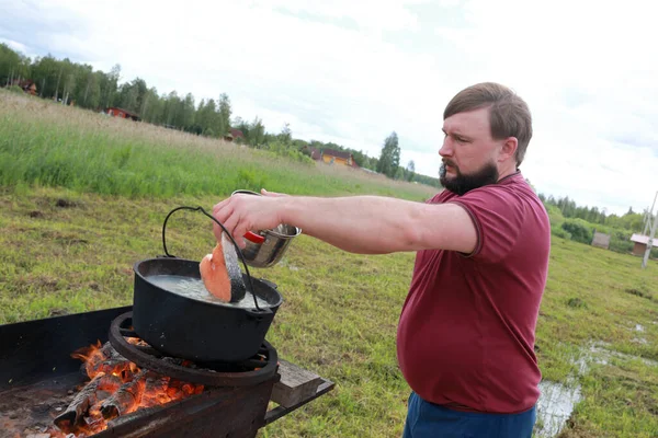 Uomo Mette Salmone Nel Calderone Cucinare Zuppa Pesce Russo Ukha — Foto Stock