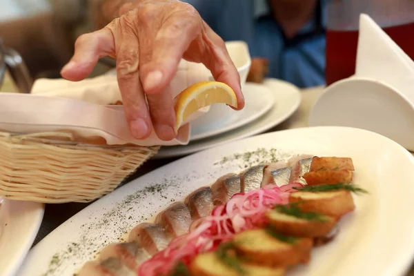 Osoba Wyciska Sok Cytryny Śledziu Restauracji — Zdjęcie stockowe