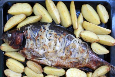 Fırında sazan ve sebze.