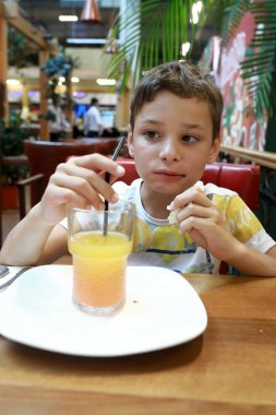 Restoranda limonata içen bir çocuğun portresi
