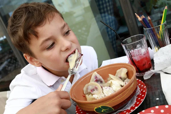 Kid Έχει Vareniki Στη Βεράντα Του Εστιατορίου — Φωτογραφία Αρχείου