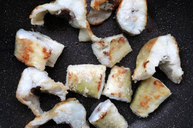 Tavada kızarmış navaga balığı parçaları.