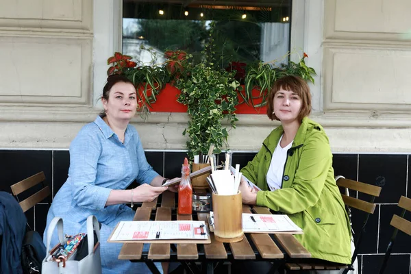 Dos Mujeres Con Libros Menú Terraza Del Restaurante —  Fotos de Stock