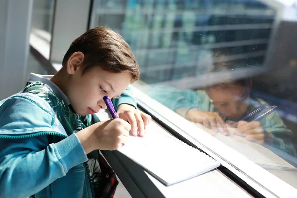 子供は空港でノートに書きます — ストック写真