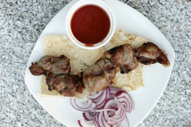 Restoranda soğanlı kuzu şiş kebap ve ketçap.