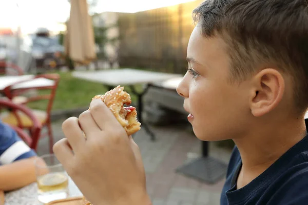 Kind Heeft Hamburger Een Buitenrestaurant — Stockfoto