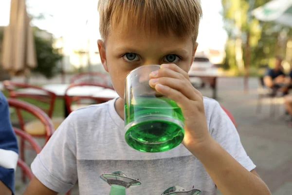 男孩在室外餐馆喝绿色柠檬水 — 图库照片